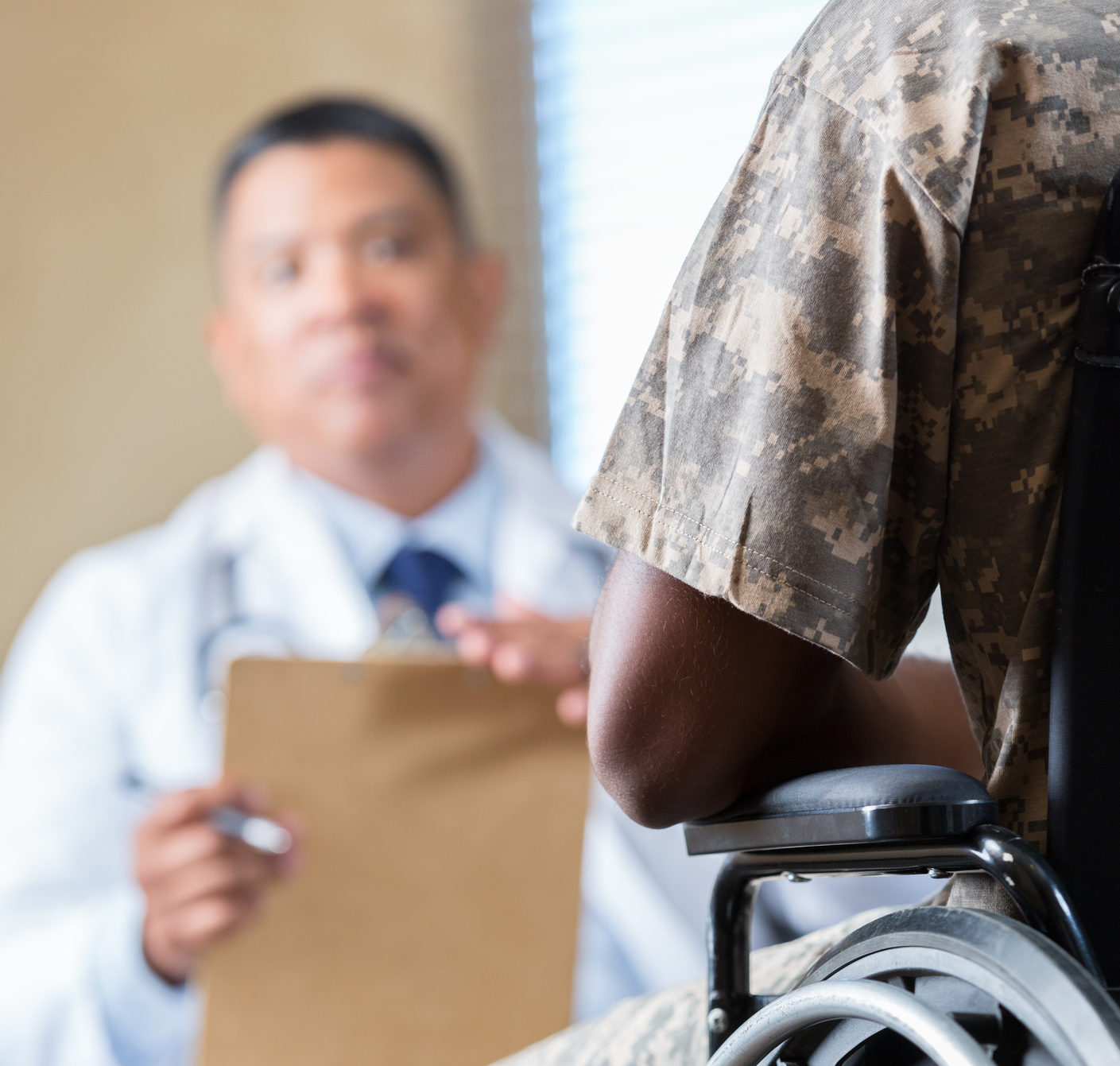 Soldier in wheelchair meeting with counselor or doctor